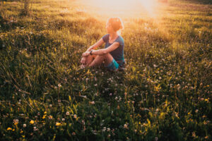woman enjoying sunset on meadow nature therapy