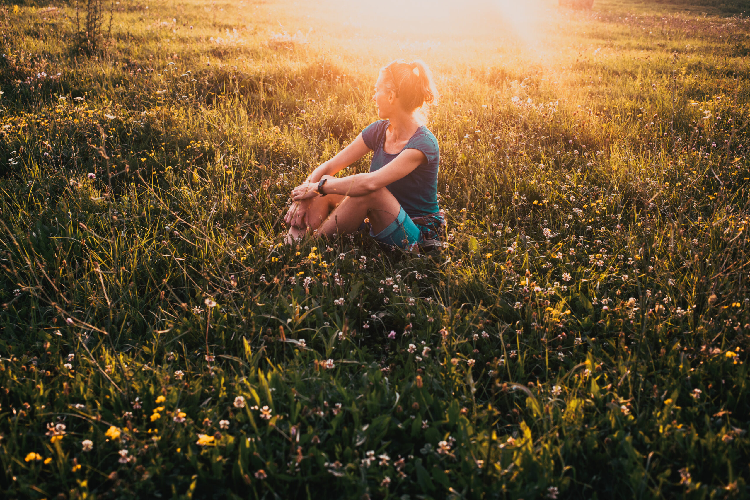 woman enjoying sunset on meadow nature therapy