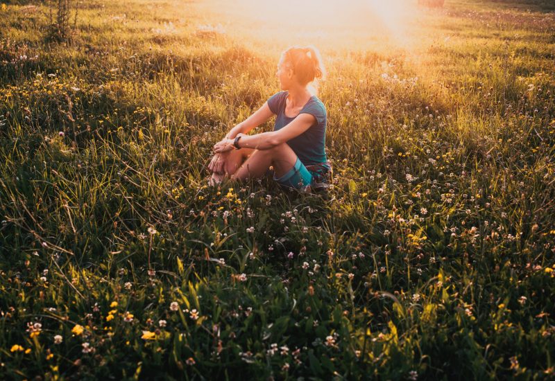 woman enjoying sunset on meadow nature therapy